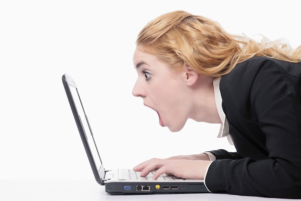 woman looking at laptop in shock